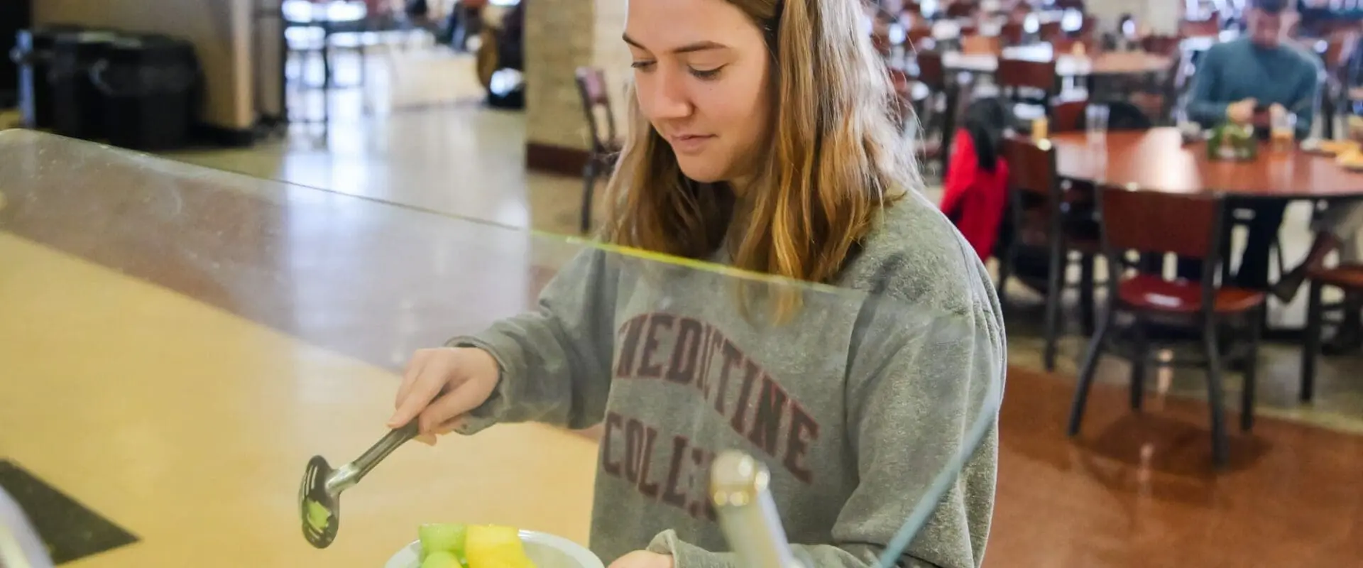 Student grabbing bowl of fruit