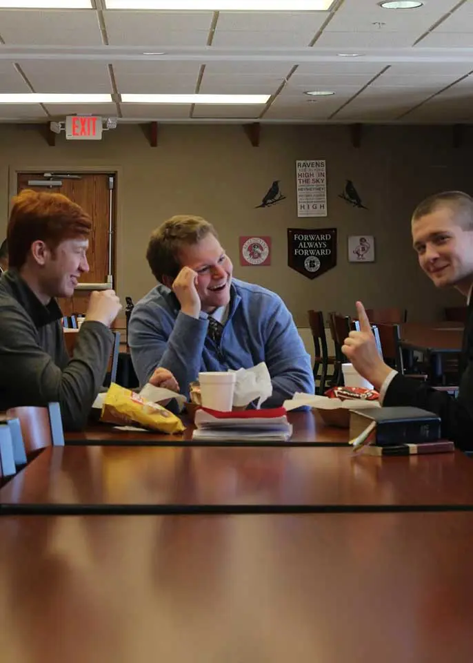 Three male students having a happy conversation over a meal