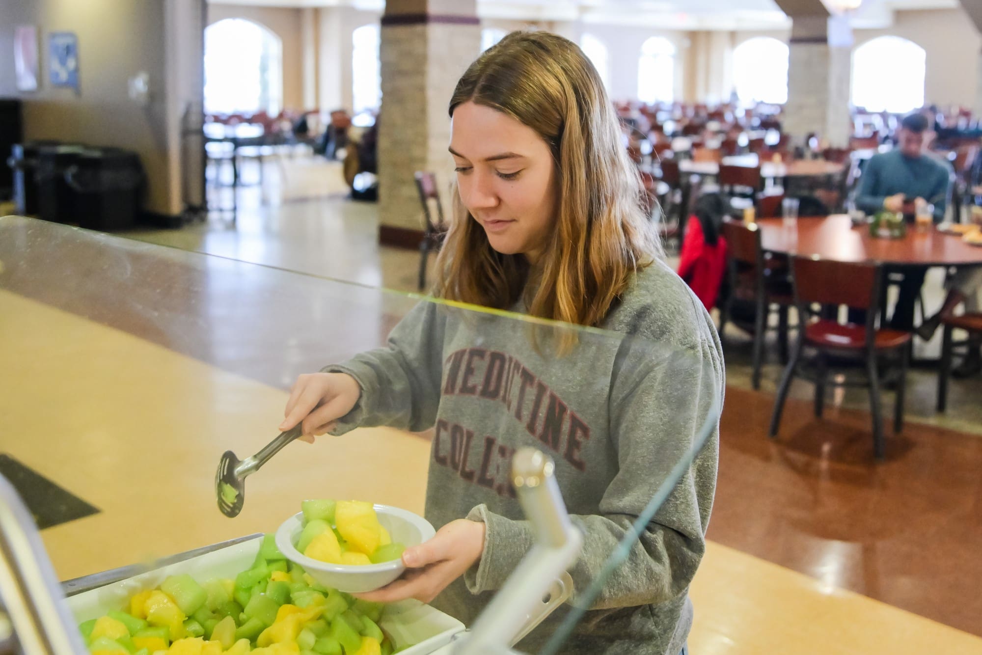 Student grabbing bowl of fruit