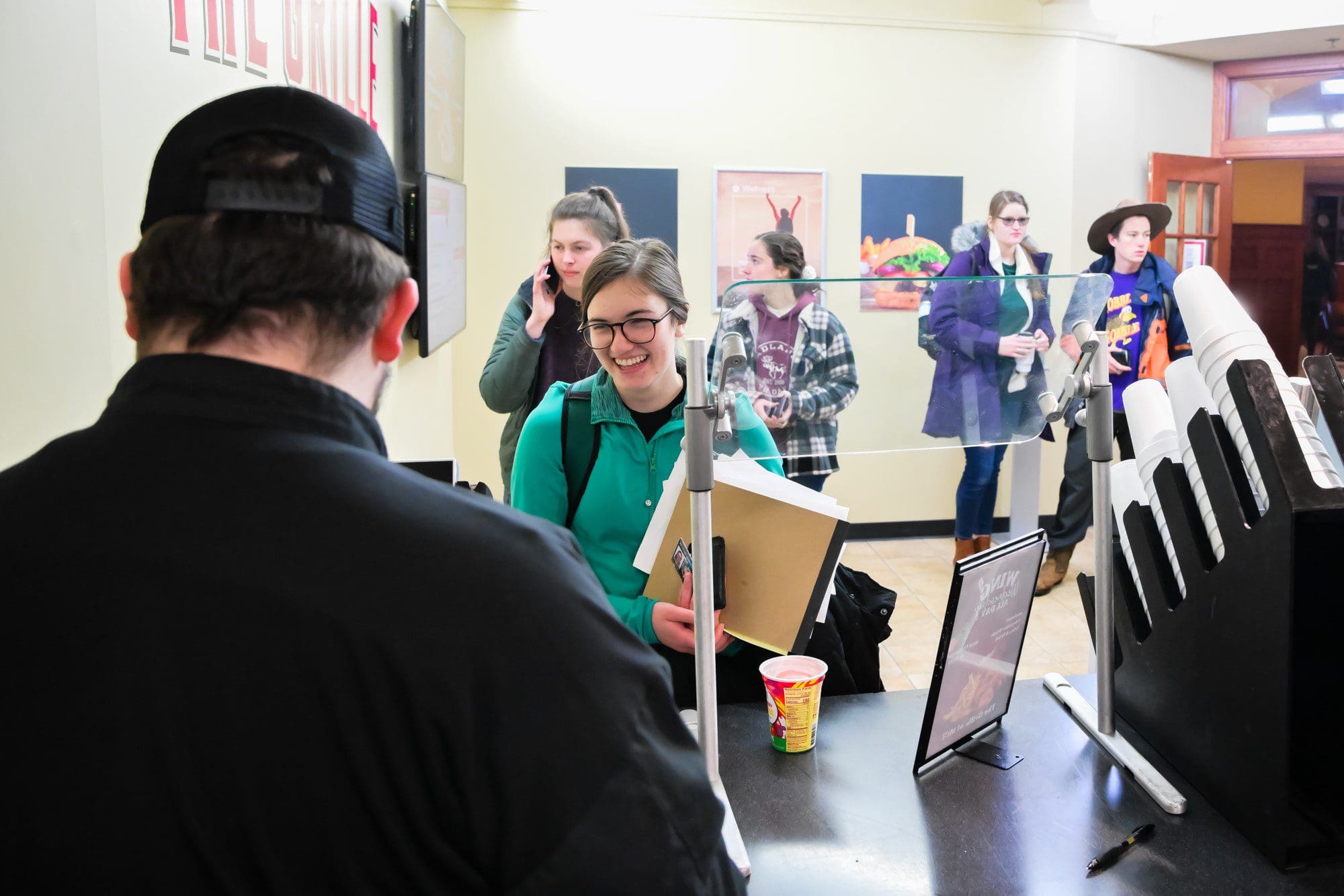 Students waiting in line with cashier in foreground